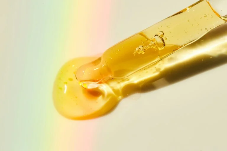 a dropper releasing golden liquid