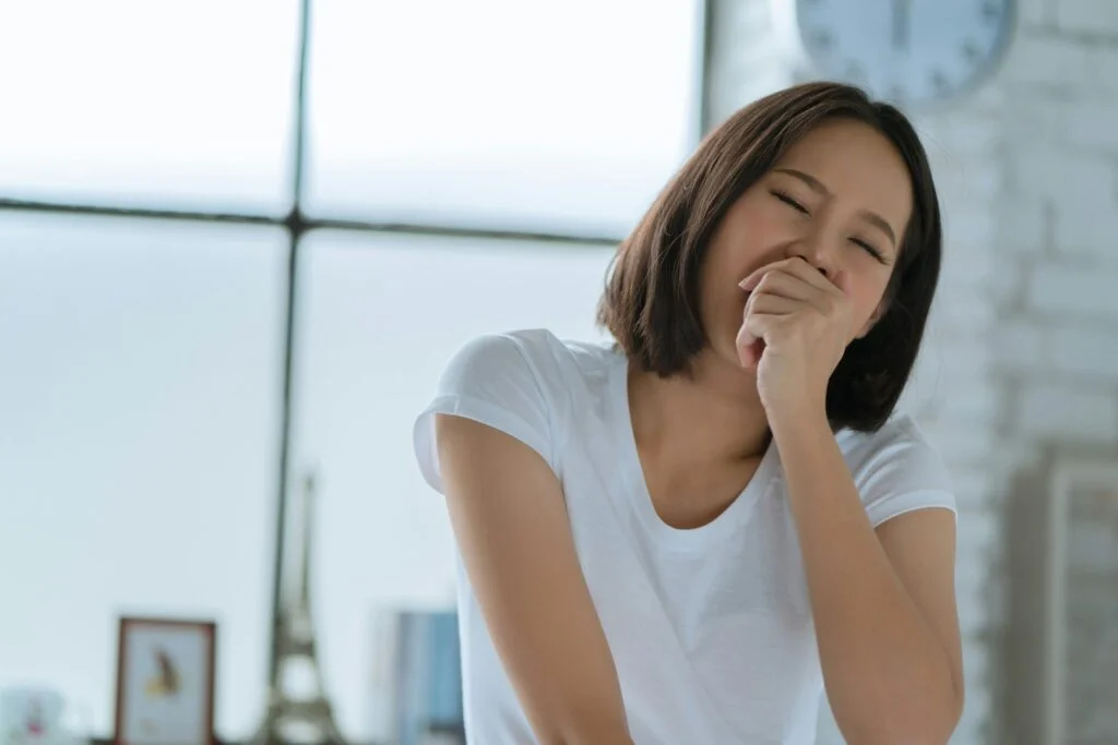 A woman yawning as she wakes up