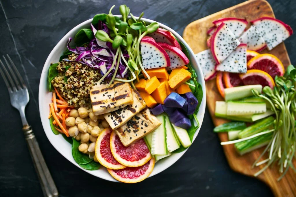 A colourful bowl of chickpeas, quinoa, tofu, vegetables and fruit