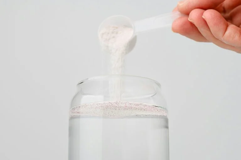 A scoop of magnesium powder being poured into a glass of water