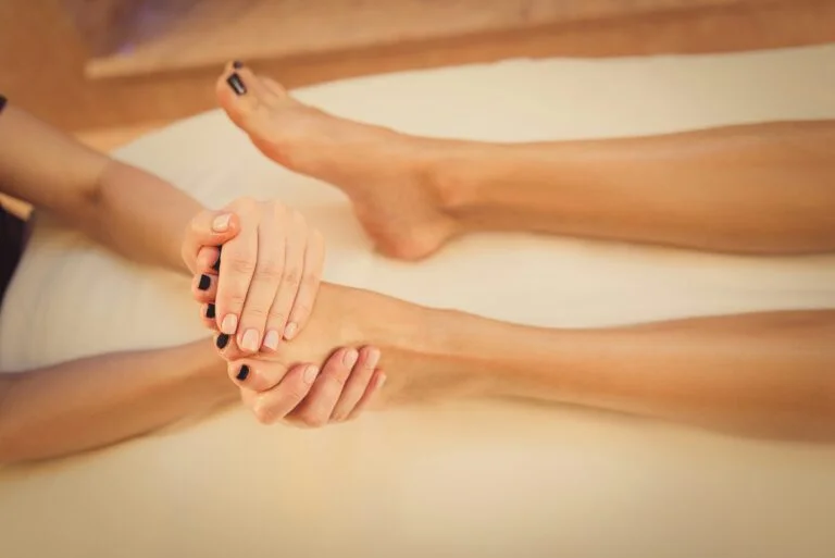 A woman massaging another woman's foot