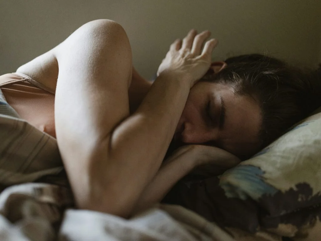 A woman struggling to sleep in bed