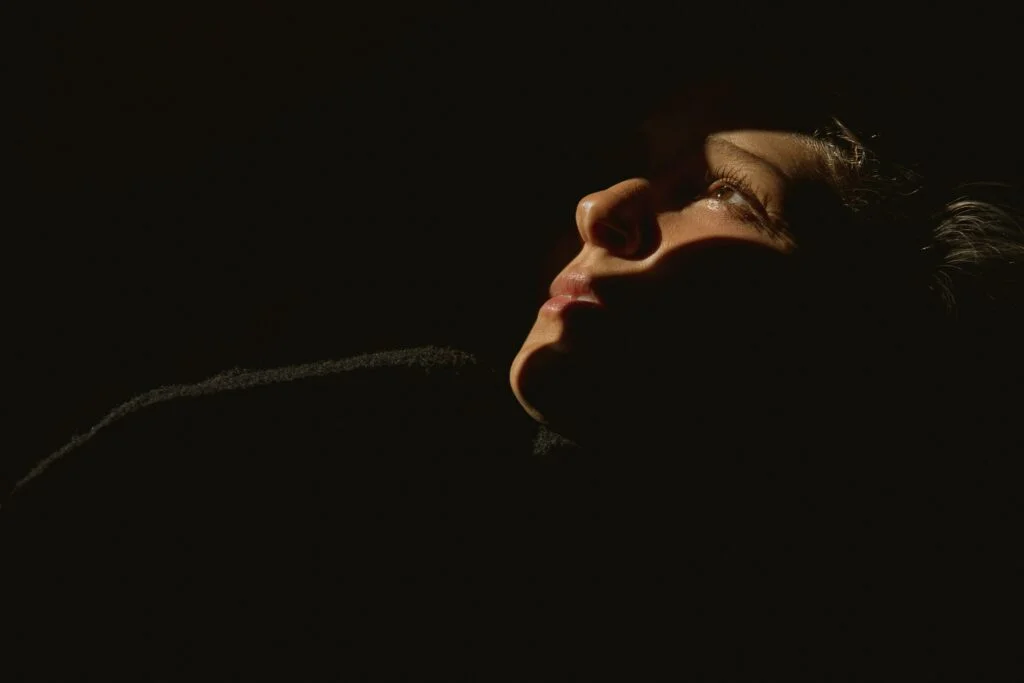 A woman with her eyes open in the dark