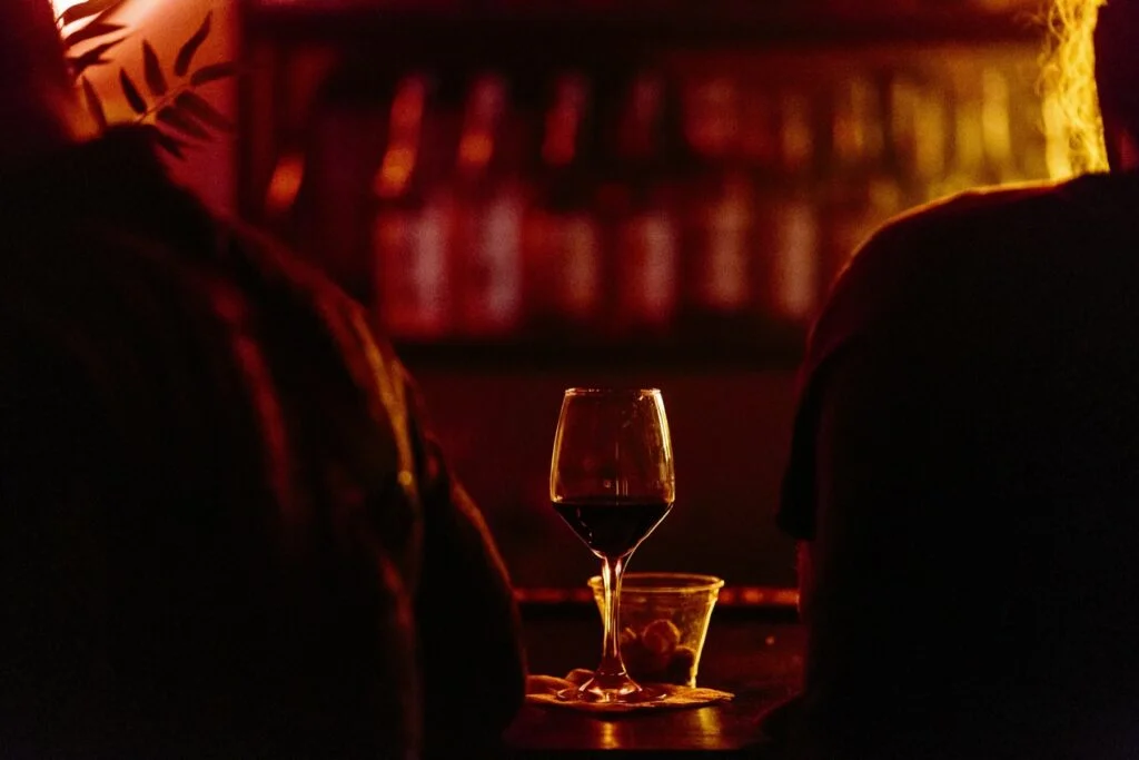 Glass of red wine on a bar table late in the evening