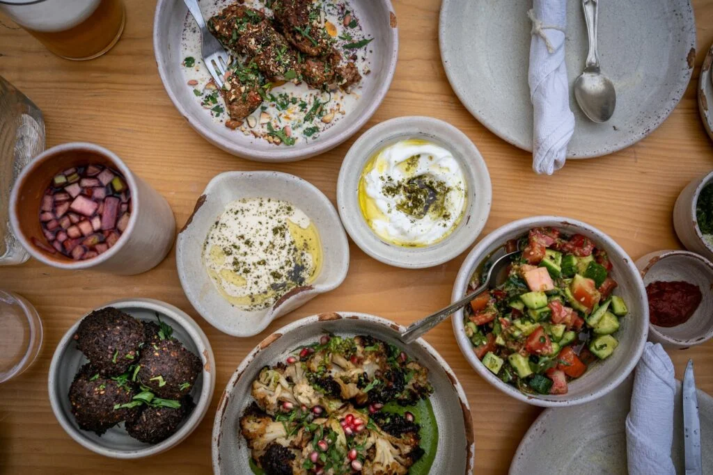Mediterranean-style dishes with salads, dips and grilled food on a table