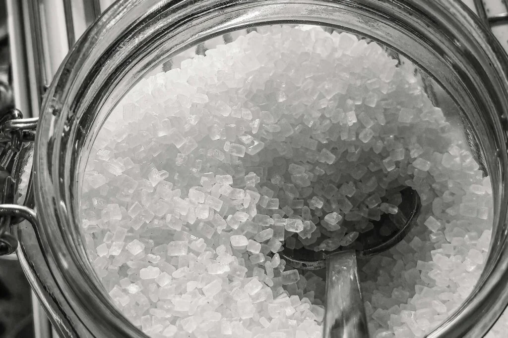 Glass jar of white mineral salt crystals