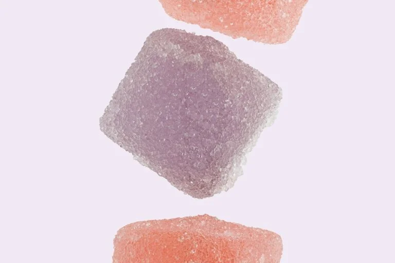 Pink and purple gummies against a pale background
