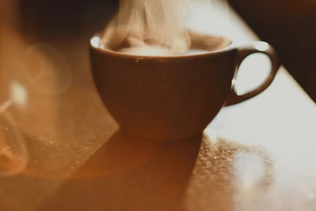 Steaming cup of mushroom coffee on a wooden table