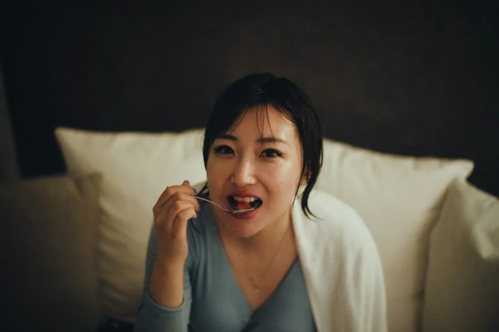 Woman eating a snack on the sofa in the evening