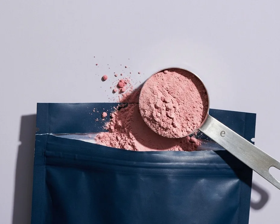 A scoop of Evopure magnesium glycinate powder over the open pouch
