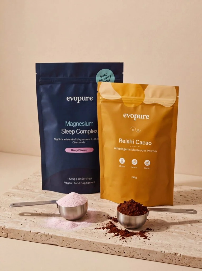 Magnesium and Reishi Cacao pouches with scoops on travertine