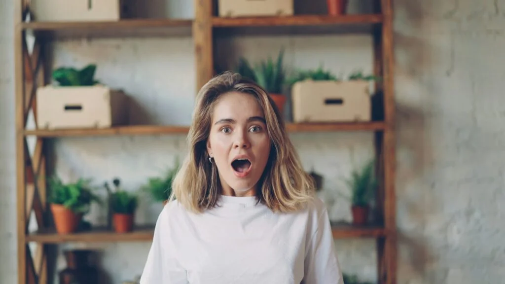 Startled young woman with wide eyes and open mouth