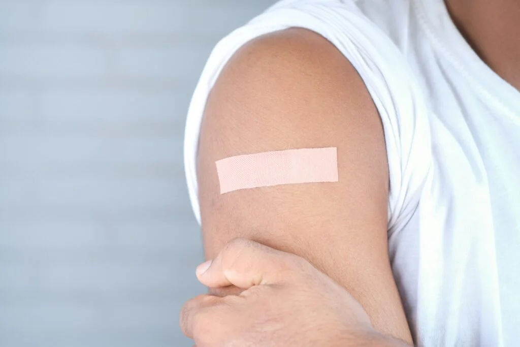 A plaster on a person's upper arm after a vaccination