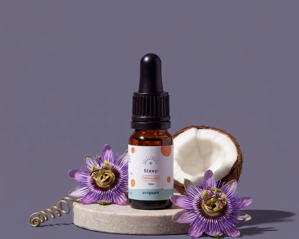 A bottle of Evopure Sleep CBD Oil on a stone plinth with passion flowers and half a coconut on a dusky purple background