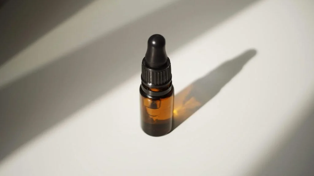 Amber dropper bottle of oil in soft sunlight