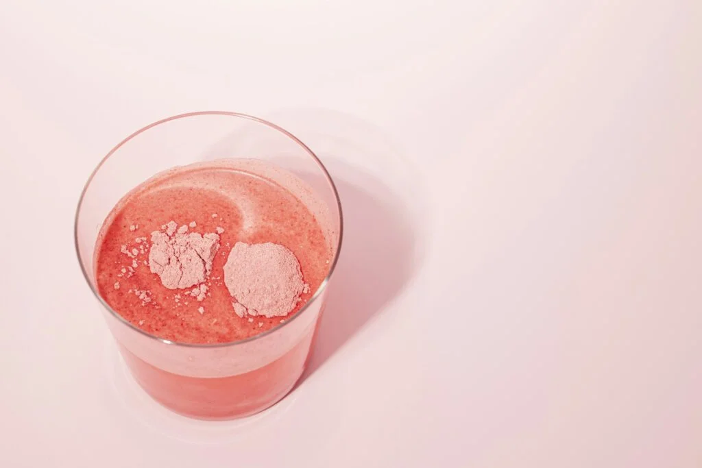 Pink drink powder dissolving in a glass of water