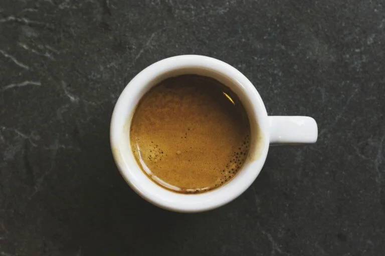 Cup of espresso viewed from above on a dark slate surface
