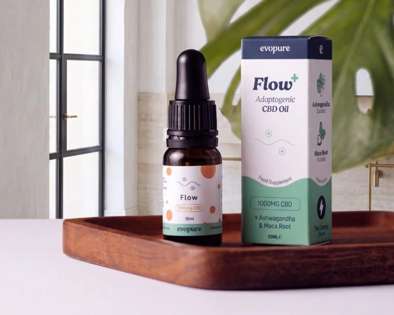 Evopure Flow CBD oil with ashwagandha and maca, bottle and box on a wooden tray