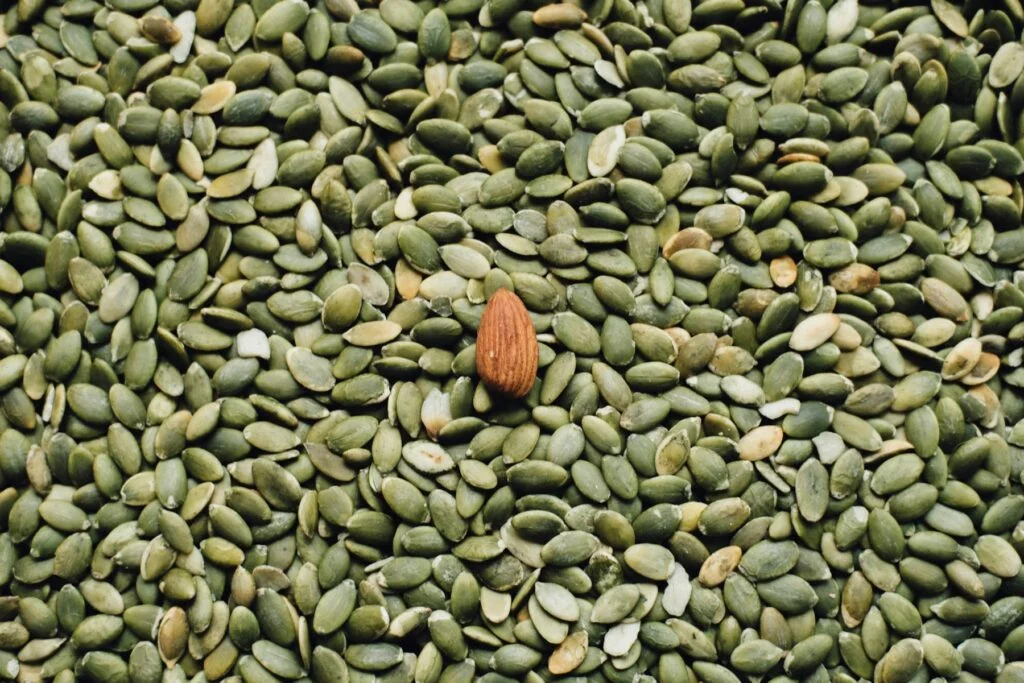 Pumpkin seeds with a single almond, both rich in magnesium