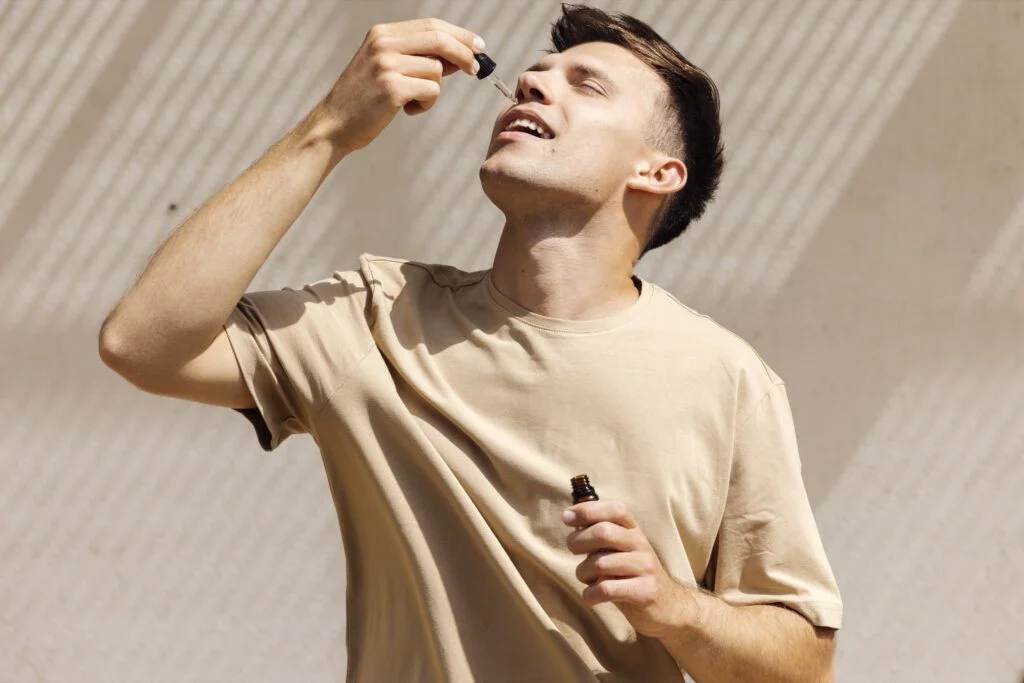 A man taking CBD oil drops under his tongue