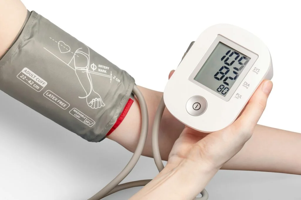A digital blood pressure monitor with a cuff on a person's upper arm
