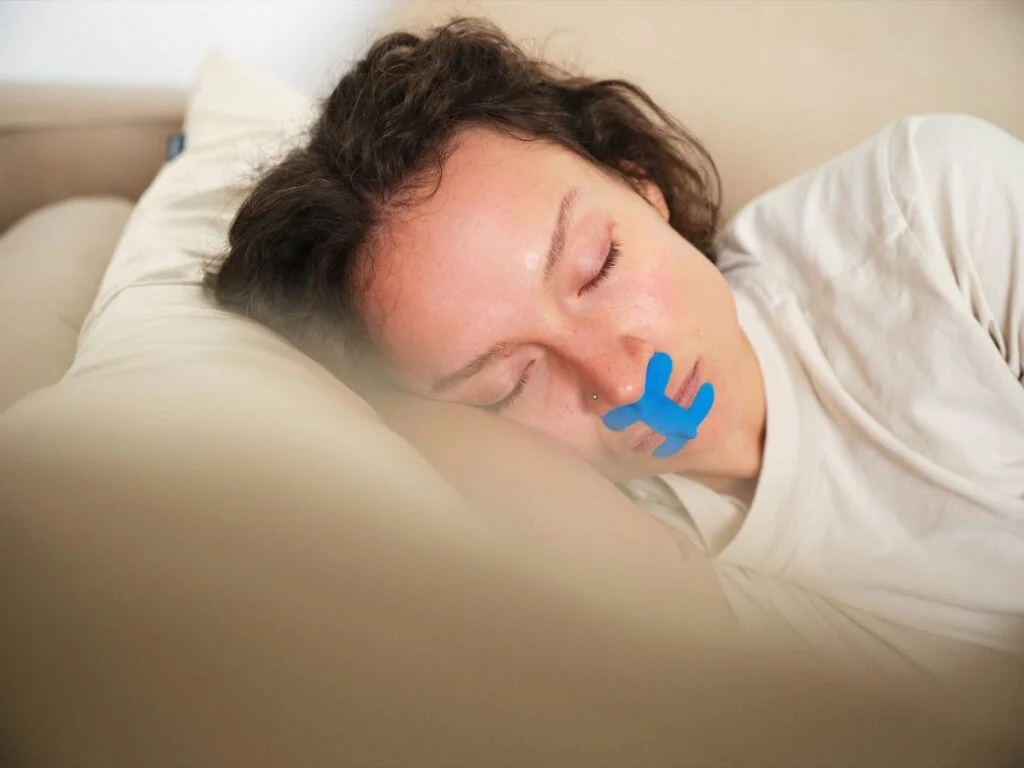 A woman lying down with tape over her mouth