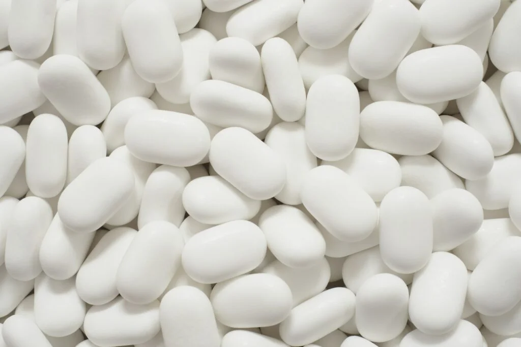 Close-up of white oval supplement tablets
