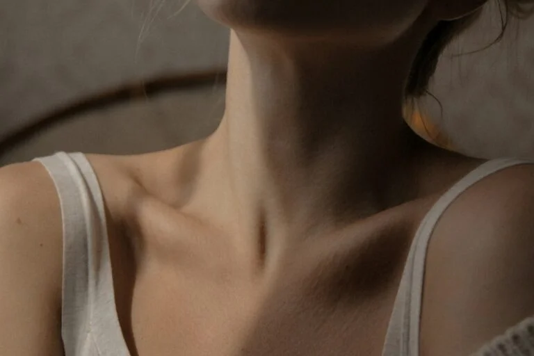 Close-up of a woman's neck and collarbones, where the thyroid gland sits