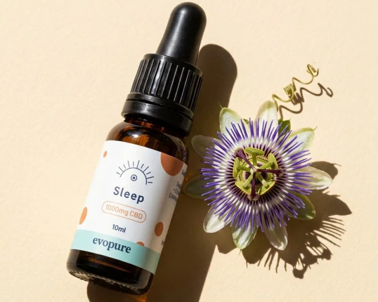 Evopure Sleep CBD oil bottle beside a passion flower