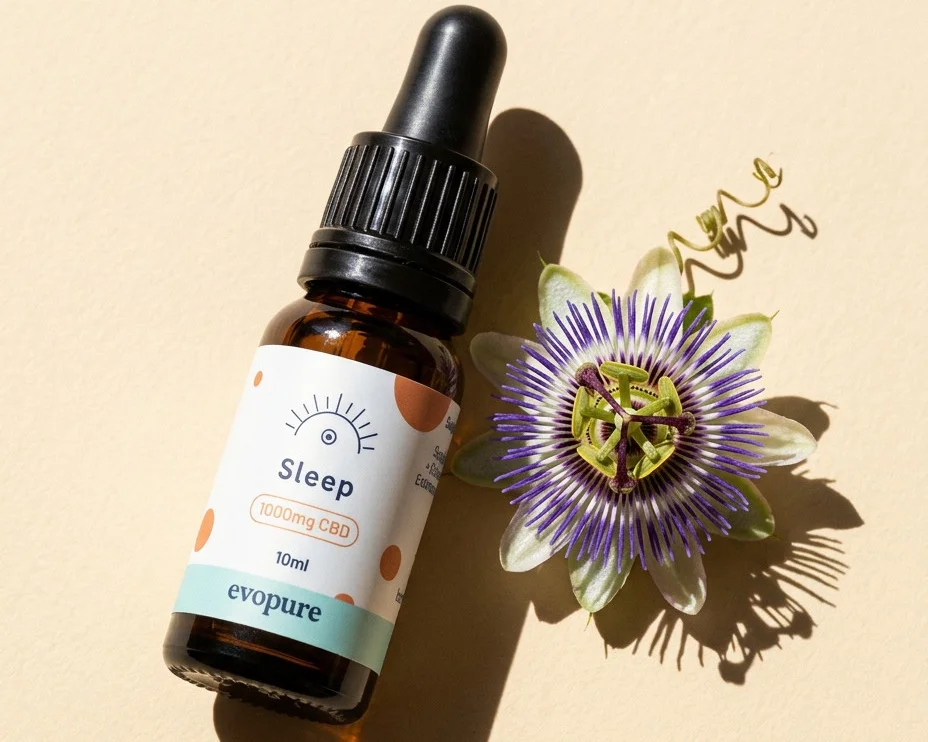 Evopure Sleep CBD oil bottle beside a passion flower