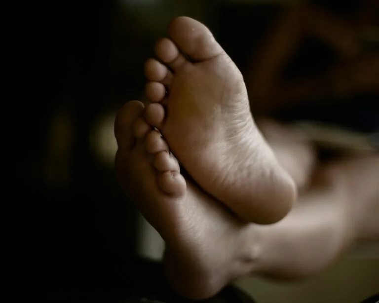 The soles of a person's bare feet resting up