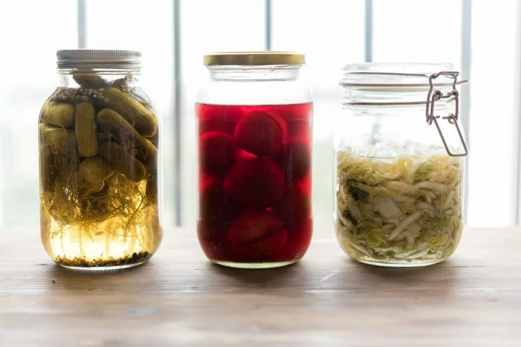 Jars of pickles, beetroot and sauerkraut on a windowsill