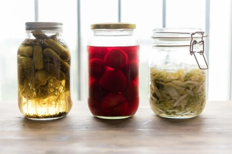 Jars of pickles, beetroot and sauerkraut on a windowsill