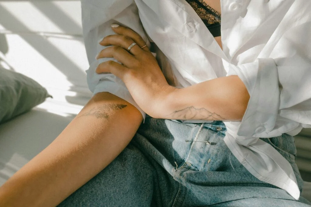Hand holding a forearm, as if soothing itchy skin
