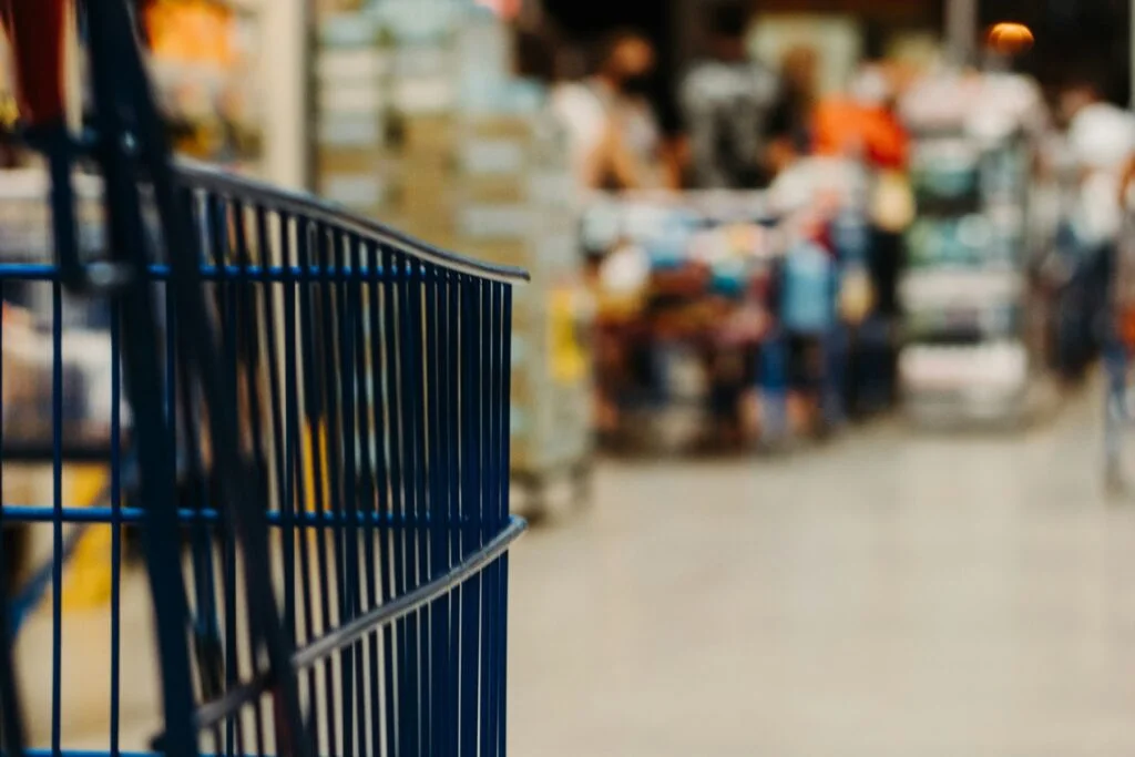 Blue shopping trolley in a blurred supermarket aisle