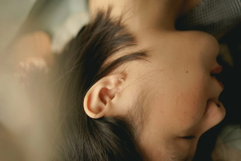 Close-up of a woman's ear as she lies in bed