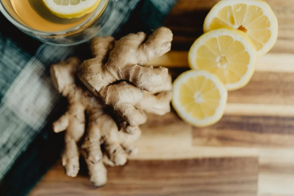 Fresh ginger root and lemon slices on a wooden board