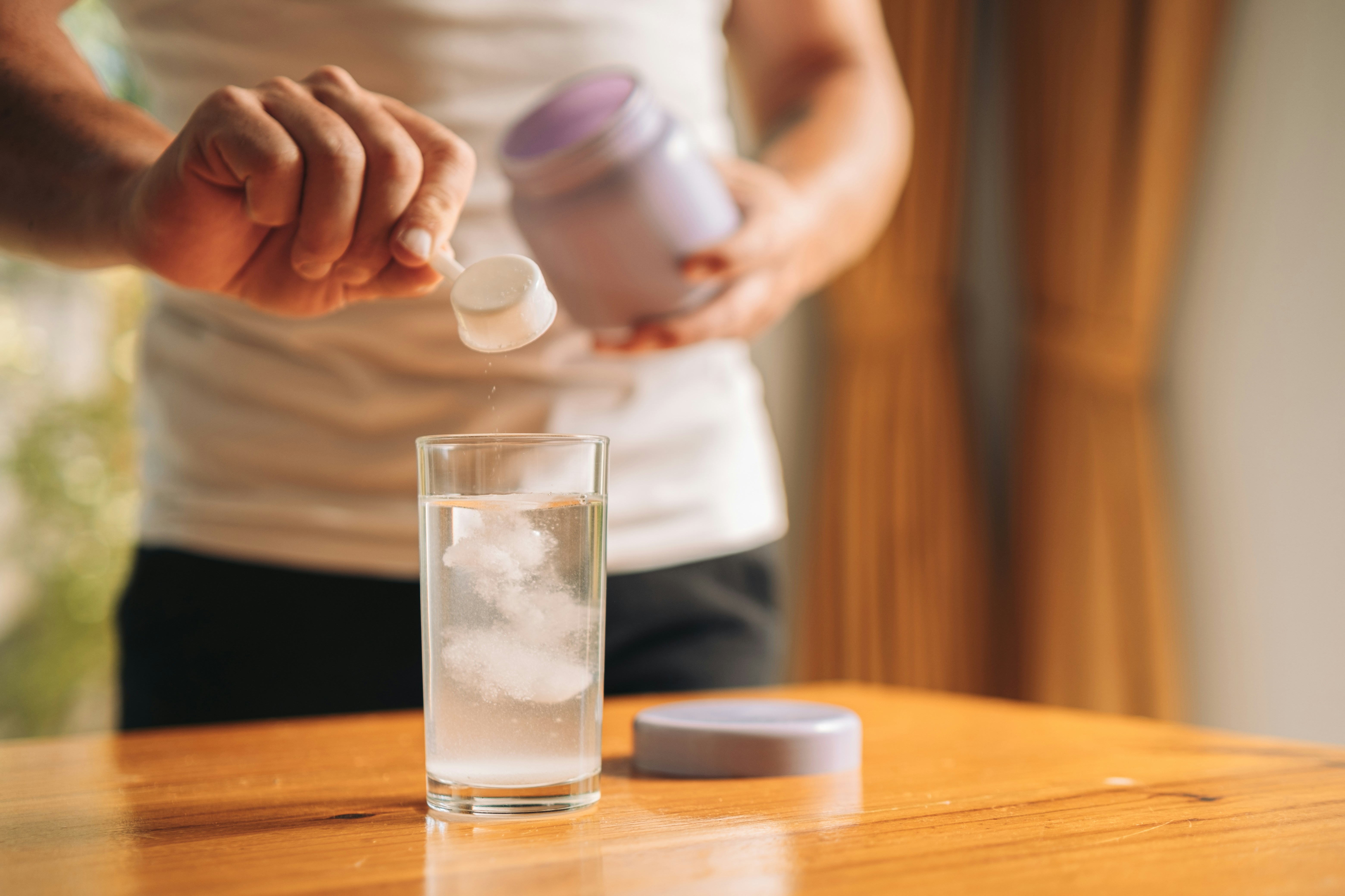 A person holding magnesium powder putting it into a cup with a scooper