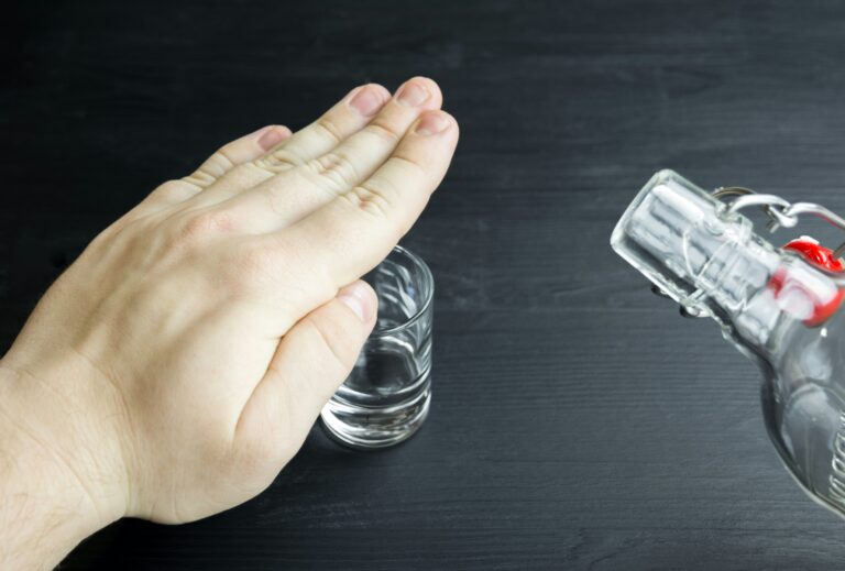 a hand covering the glass saying no to alcohol