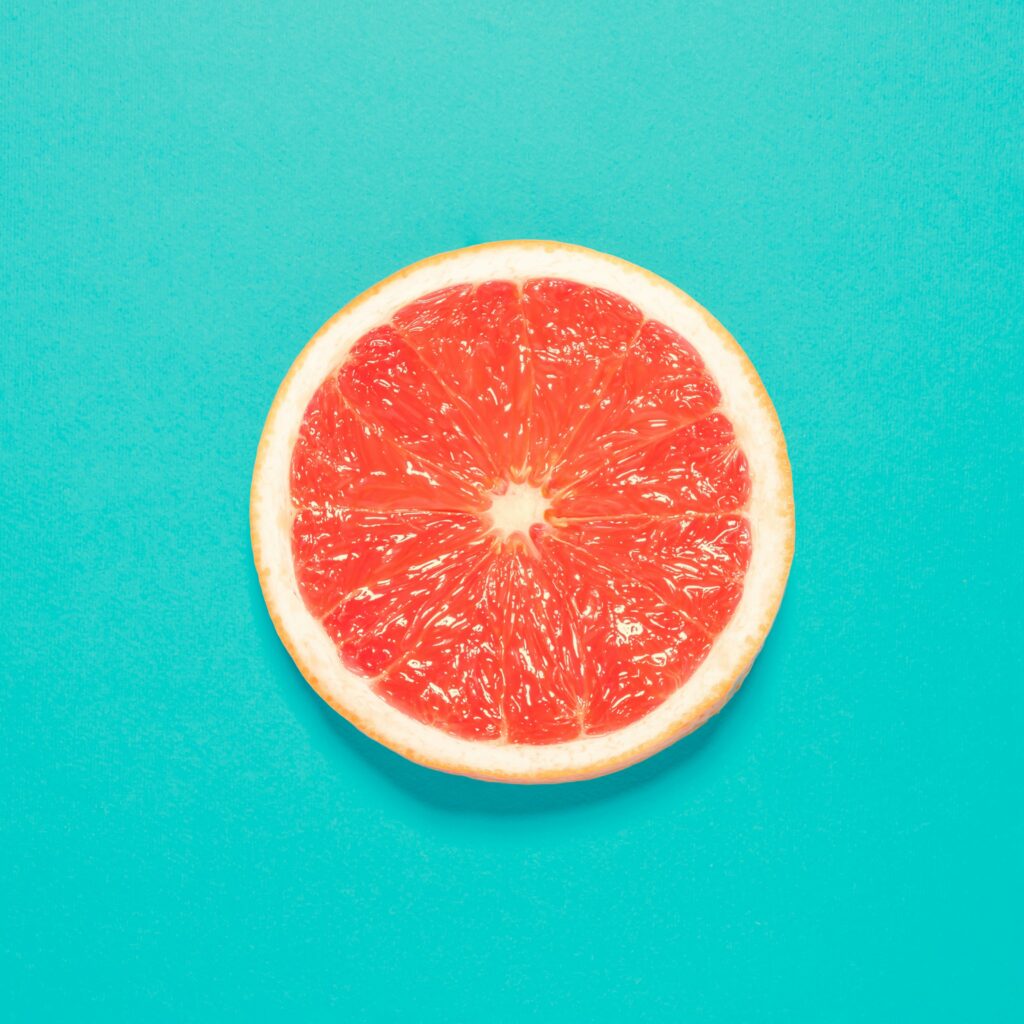 Grapefruit slice on paset bluebackground