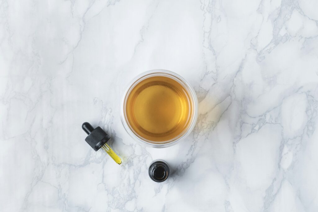 cbd dropper with a glass of alcohol