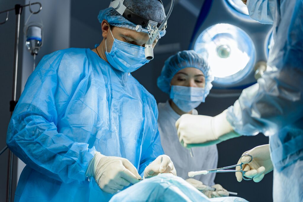 Busy surgical team doing an operation with help of medical equipment