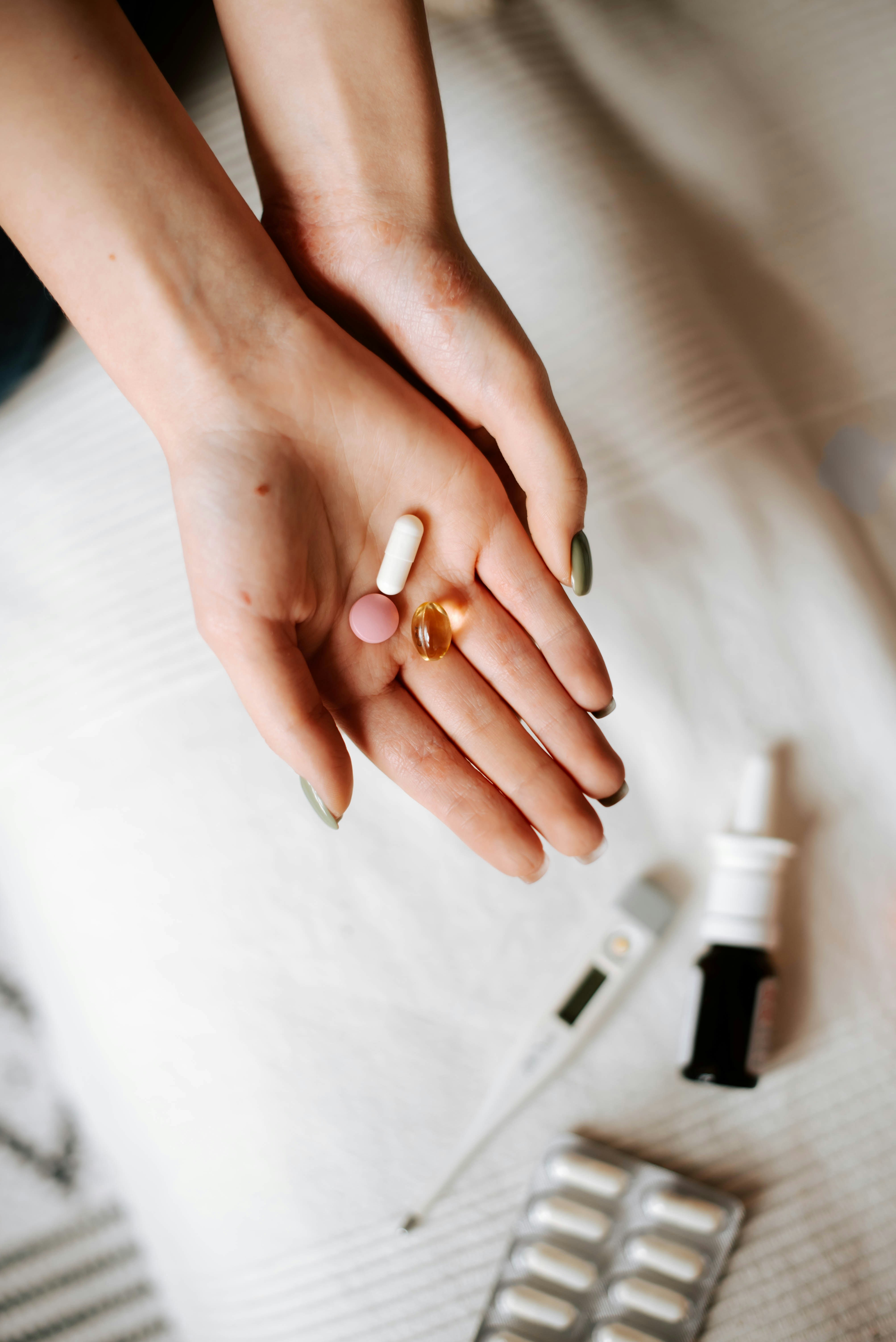 a womans hand holding pills