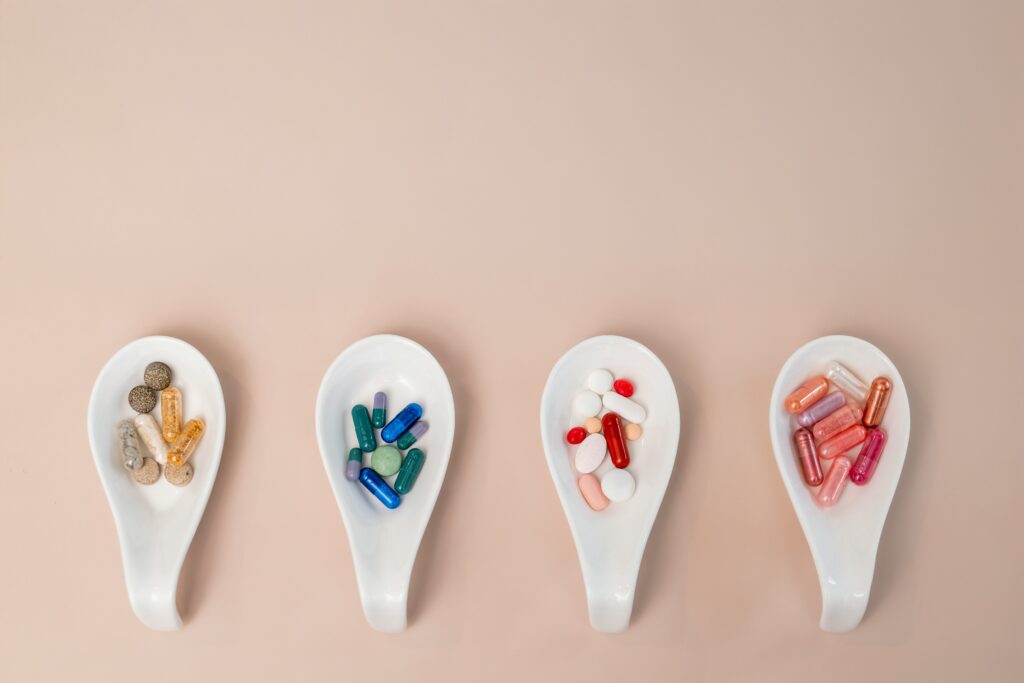 a row of spoons with different capsules