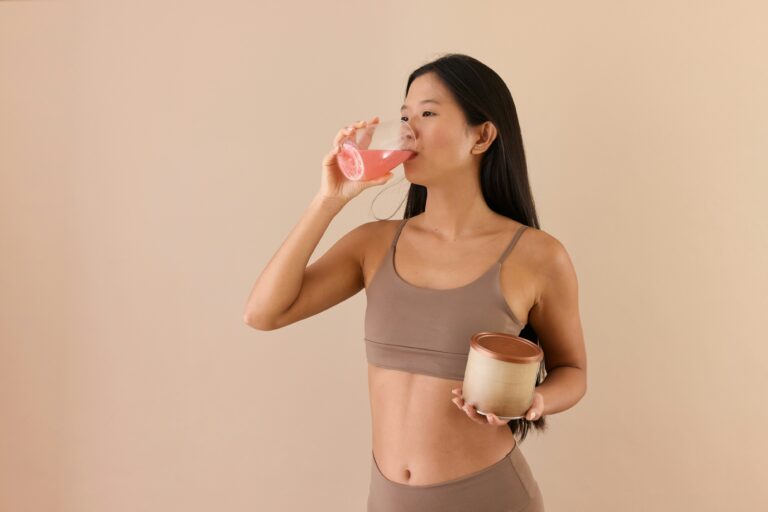 a woman drinking from a cup with powder in hand
