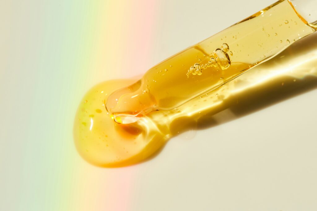 a dropper releasing golden liquid