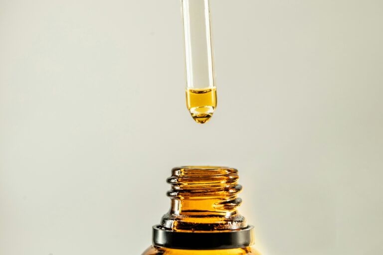 a dropper dispensing oil into a bottle