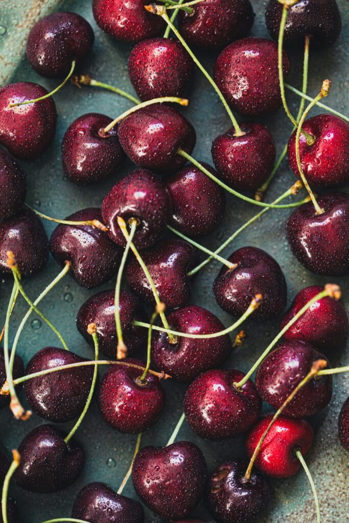 a bowl filled with cherries on table