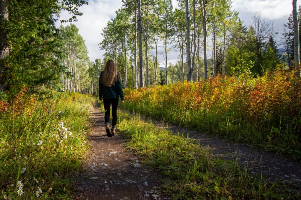 Woman walking along a woodland path in autumn